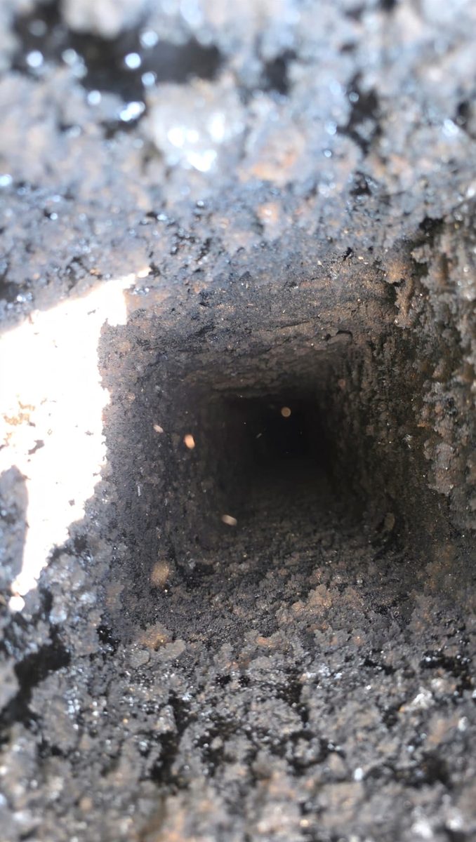 Chimney flue lined with heavy creosote and soot before cleaning